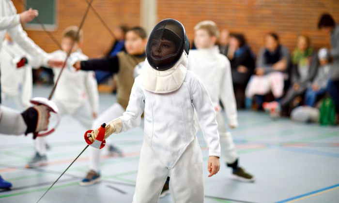 Junge beim Fechten mit Helm und Schutzkleidung &#40;Symbolbild&#41; © Irina Schmidt/AdobeStock